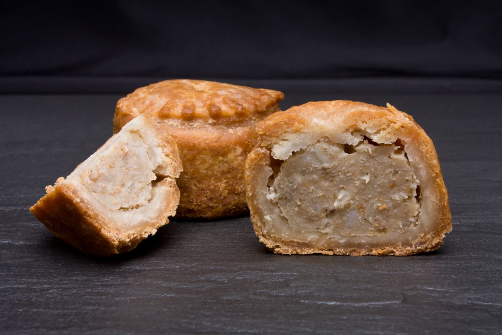 Traditional,English,Pork,Pie,From,Low,Perspective,Against,Dark,Slate